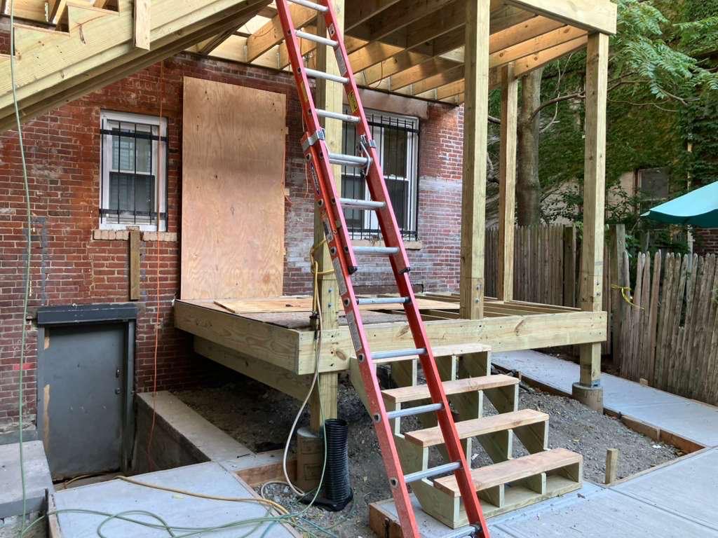 Multi-Level Deck Construction - Exposed Framing on Brick Building